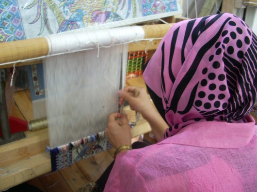 Mujer Turca tejiendo una alfombra de seda